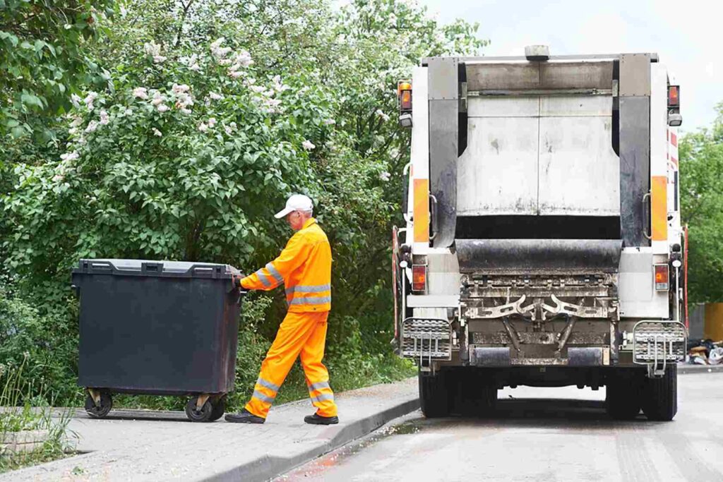 Truck collecting sorted waste for recycling in Dubai with greenery in background