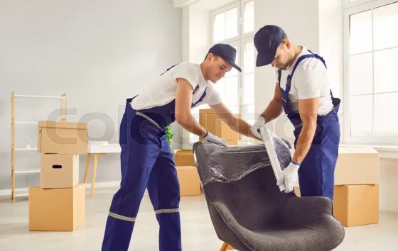 Professional packing crew wrapping furniture in a Downtown Dubai apartment