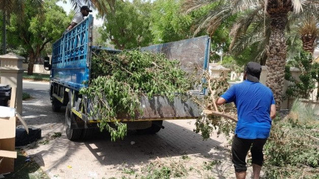 Delivery truck unloading white sand and cement bags at a UAE construction site