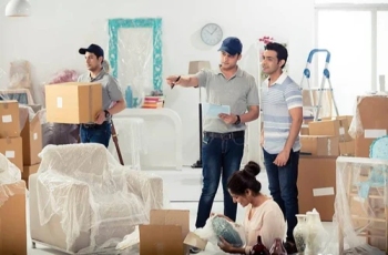 Team of professional packers packing boxes in a modern Dubai apartment