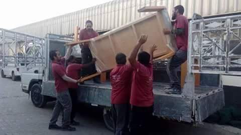 Office furniture and junk being loaded onto a rubbish removal truck in Dubai